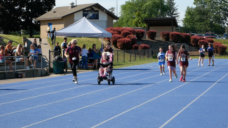 Athletes moving down the track during unified sports event