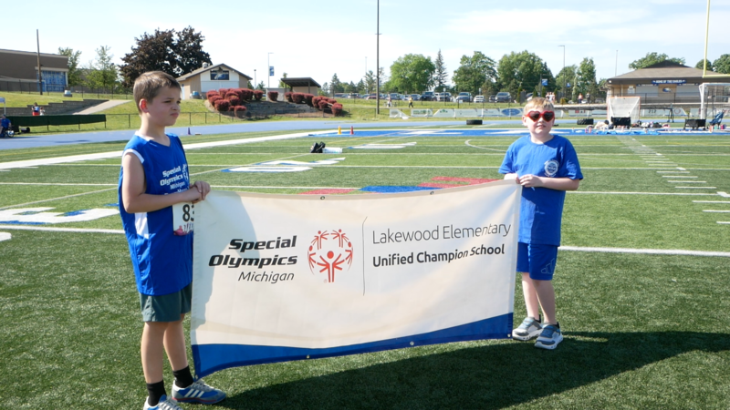 photo of two students holding a special olympics banner