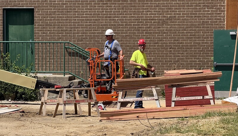 Construction crews working on site with brown dirt and heavy machinery
