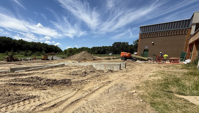 Construction crews working on site with brown dirt and heavy machinery