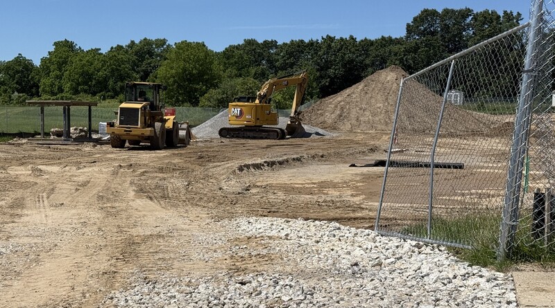 Construction crews working on site with brown dirt and heavy machinery
