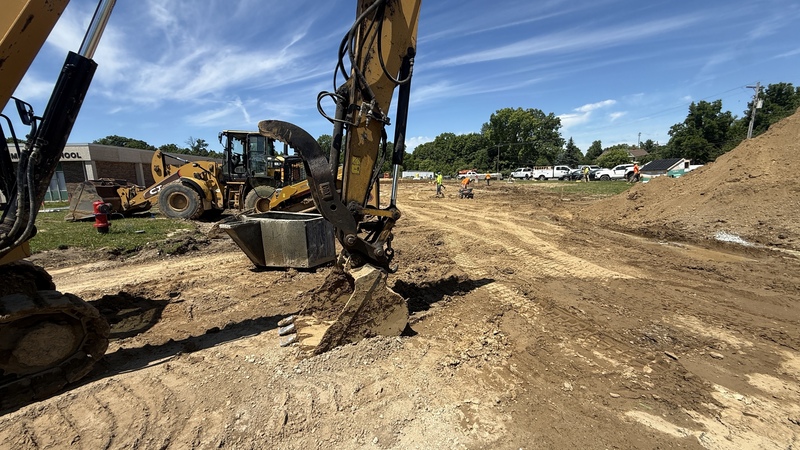 Construction crews working on site with brown dirt and heavy machinery
