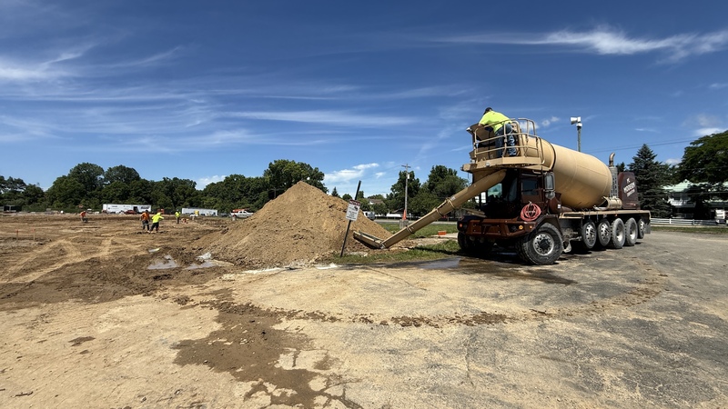 Construction crews working on site with brown dirt and heavy machinery