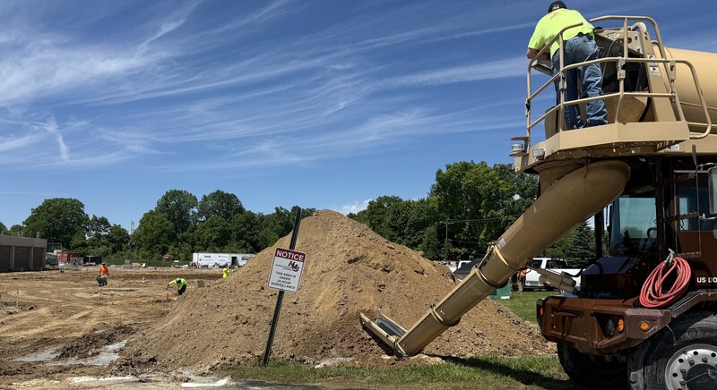Construction crews working on site with brown dirt and heavy machinery