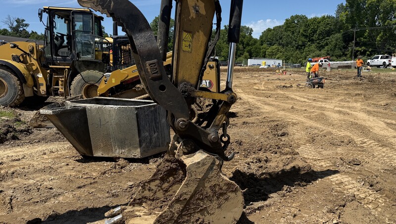 Construction crews working on site with brown dirt and heavy machinery