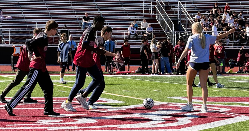 Photo of soccer players on the field with dribbling a ball