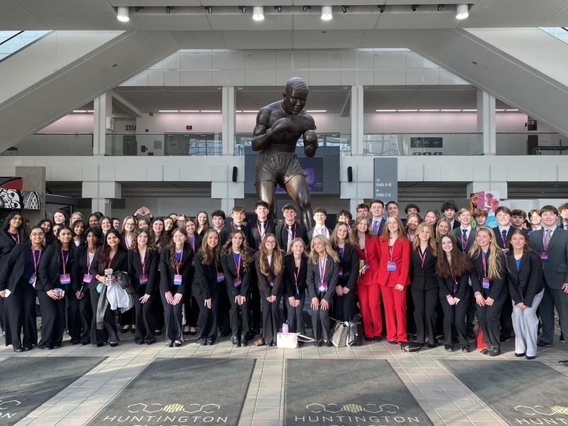 Several HVS students in front of DCA sign at conference in Detroit