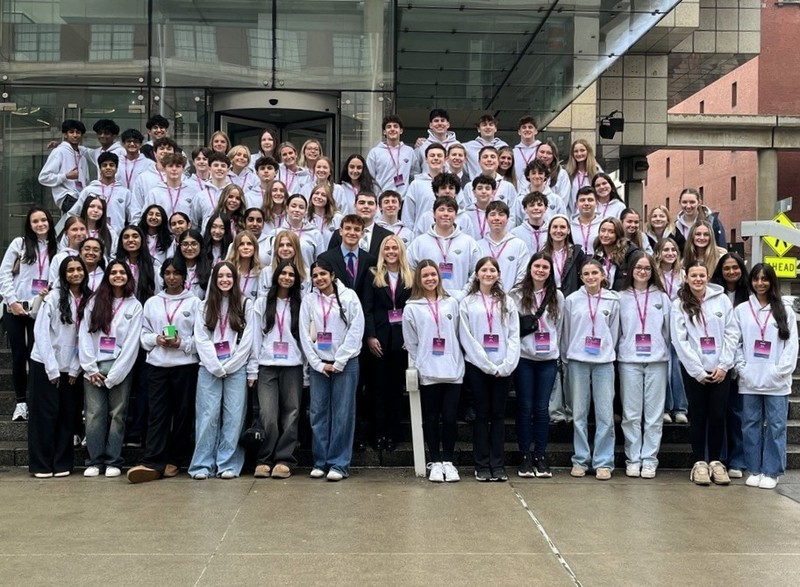 Several HVS students in front of DCA sign at conference in Detroit