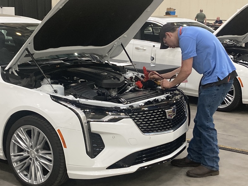 Student working under the hood of a car