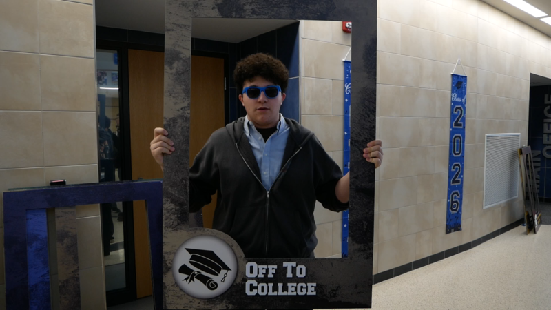 Student holding 'off to college' sign