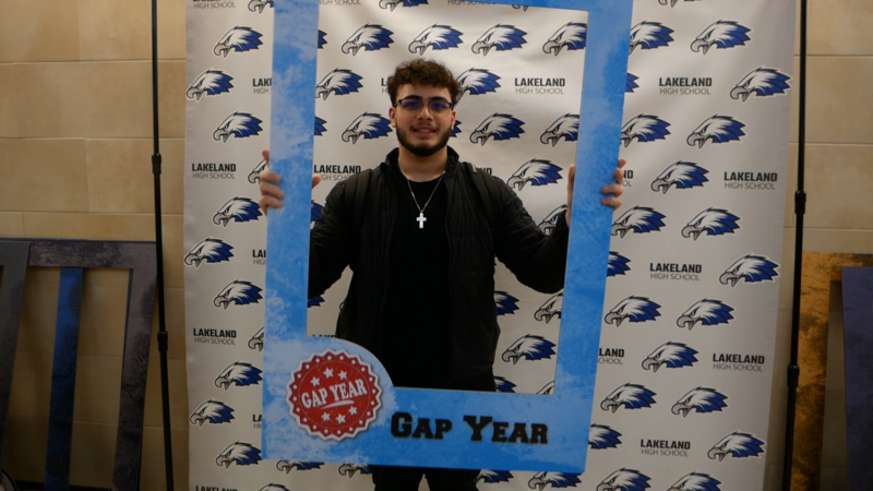 Student holding 'gap year' sign