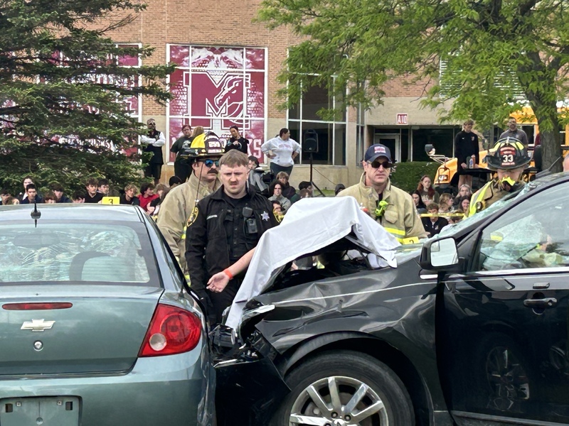 student under white blanket during mock car crash simulation