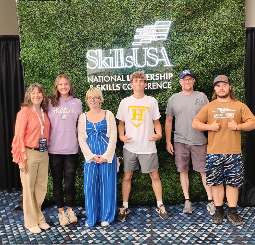 a group of people stand in front of a greenery wall with a SkillsUSA logo on the wall. Left to Right: Glenna Burden, Harlie Terrell, Chyanne Myers, Tanner Loushrie, Jeremiah Harmon, and Blake Beaumont in the Georgia World Congress Center for the SkillsUSA National Leadership & Skills Conference. Atlanta, GA