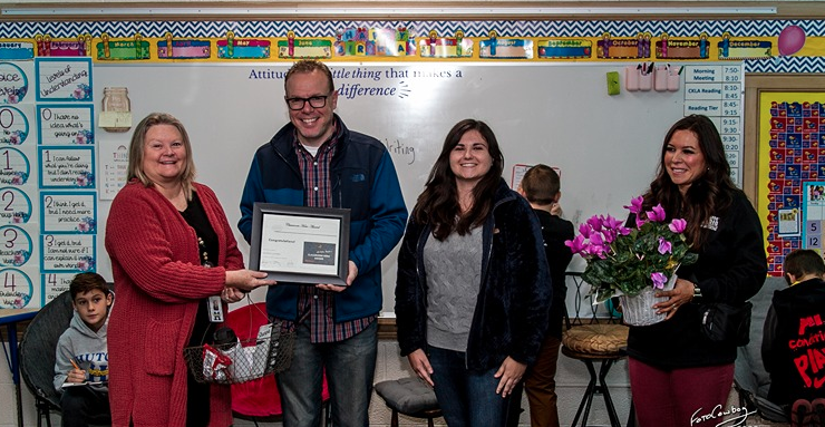 Ad Astra Radio representatives Aaron Napier, Brenna Eller and Jessica Shank present Michelle Lowden of Morgan Elementary School with gifts and a certificate for being this month's Classroom Hero recipient on Nov. 20. (Photo by the Foto Cowboy)