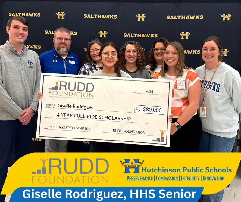 Giselle Rodriguez, Hutchinson High Senior, poses with an over-sized check declaring her rull ride Rudd Scholarship. Behind her are HHS and USD 308 staff and coaches. Bottom of image contains logos of the Rudd Foundation and Hutchinson Public Schools.
