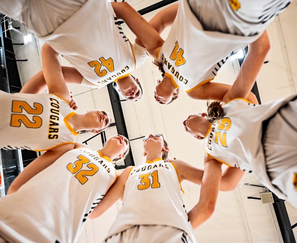 MS girls basketball players huddled up