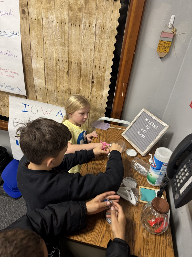 a boy and girls doing a magnet with paper clips