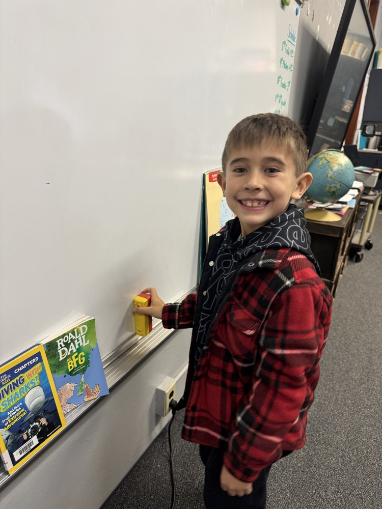 a boy smiling trying a magnet in the board