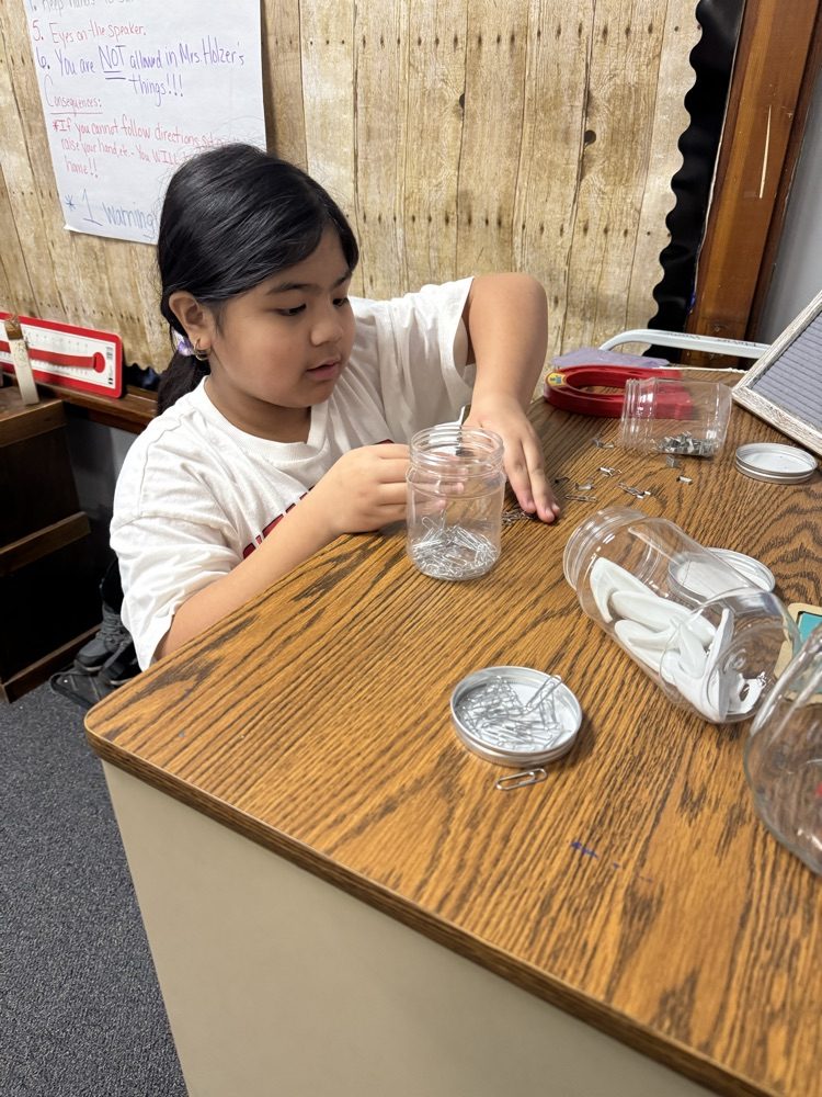 a girl trying a paperclip with a magnet