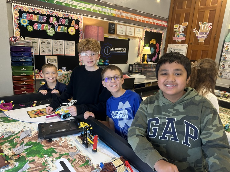 boys smiling around Lego table