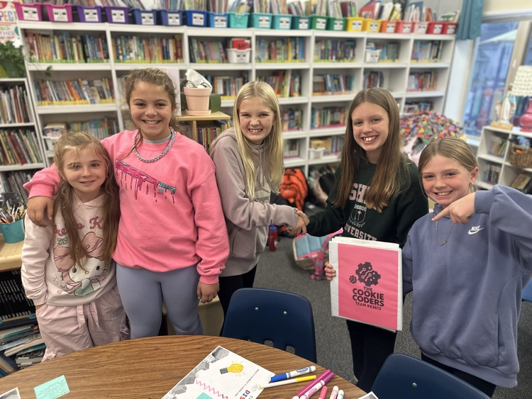girls smiling around Lego table