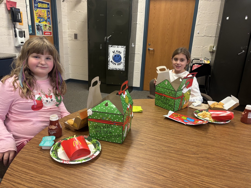 two smiling girls with grinch meals