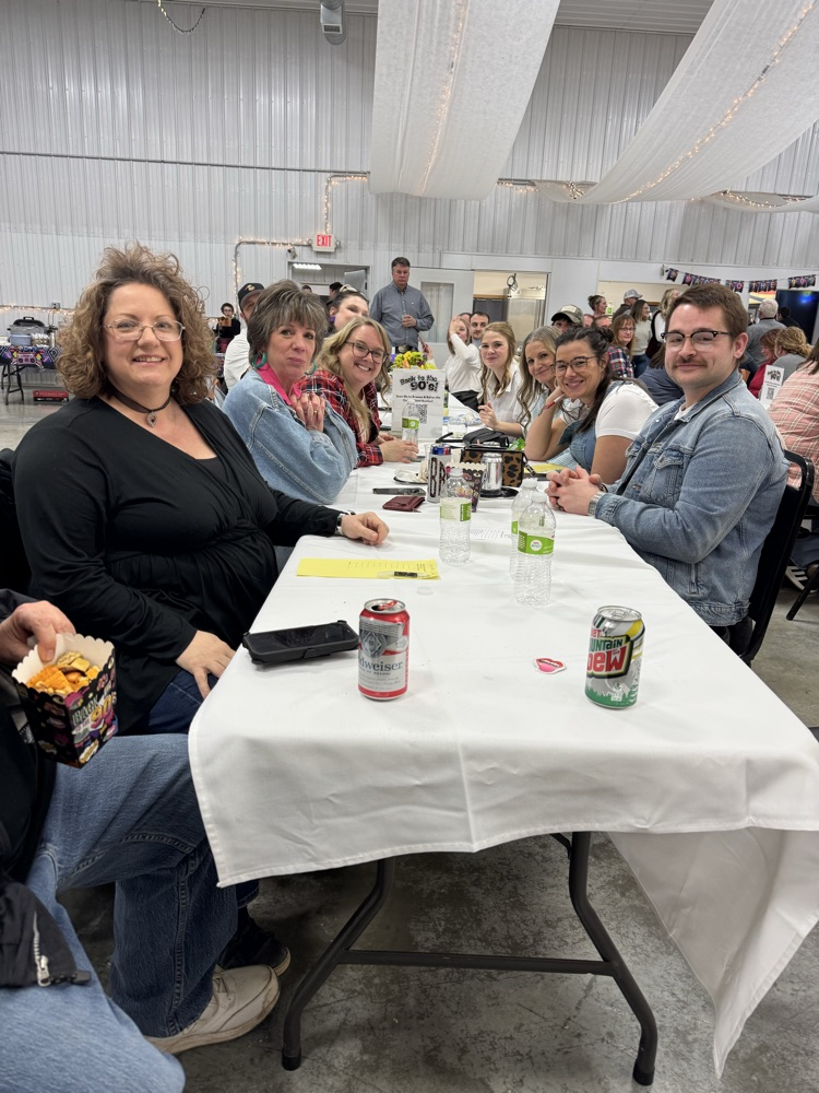 group smiling at a long white table 