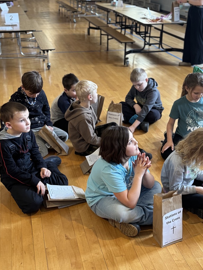 students praing in a gym