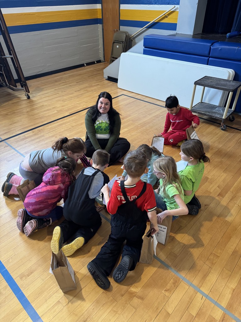 students on floor listening to a teacher
