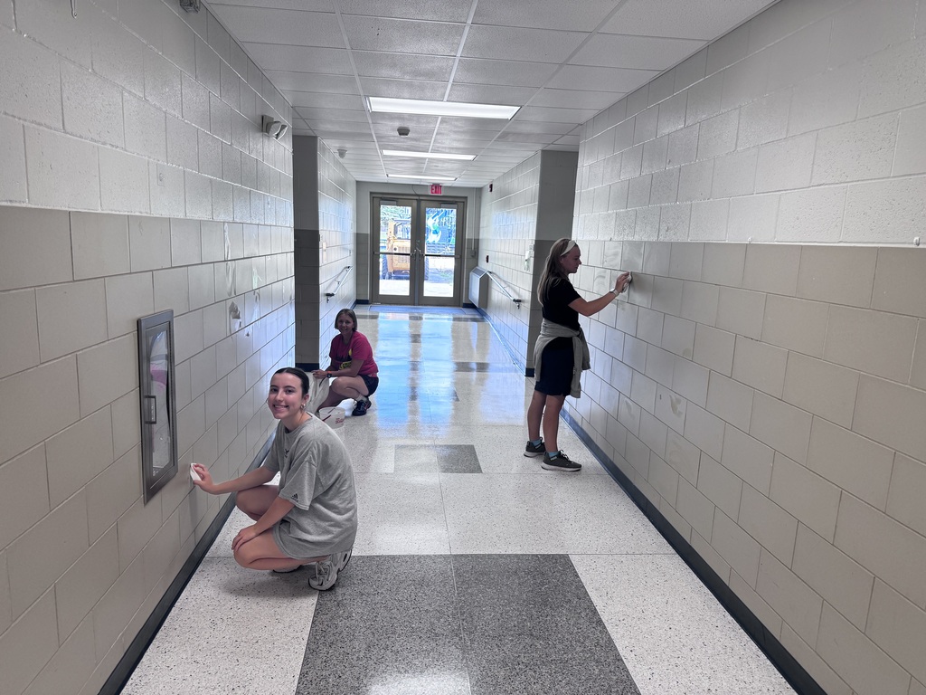 people in a halway washing walls