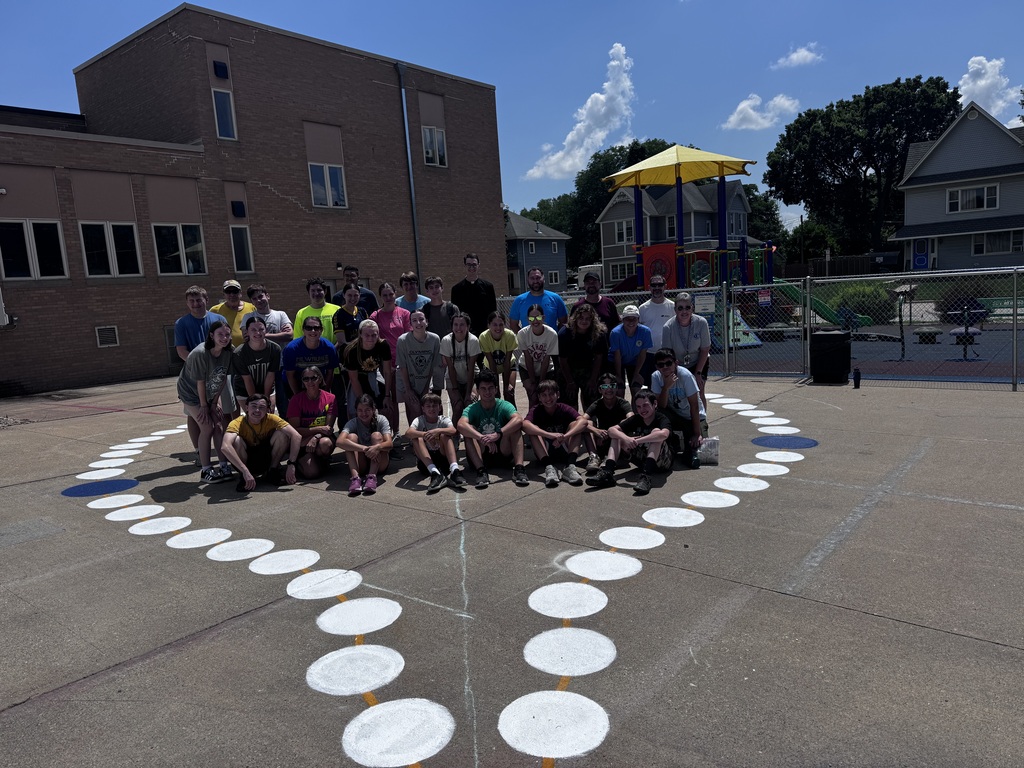 A group standing in the middle of a giant painted rosary