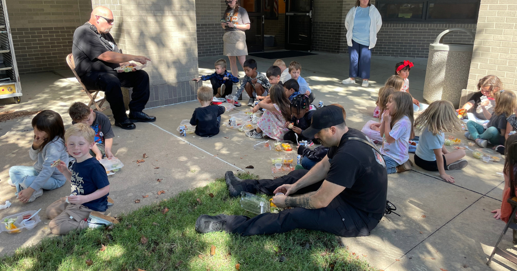 Students eating lunch with Fire Fighters