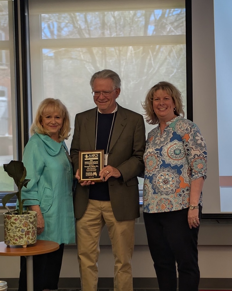 Dr. Sally McCombie, Tom Harley holding award, and Sarah Juart 