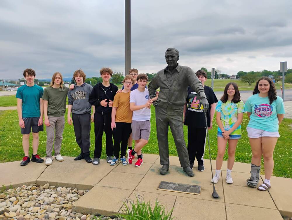 Aviation Club posing with statue of Arnold Palmer