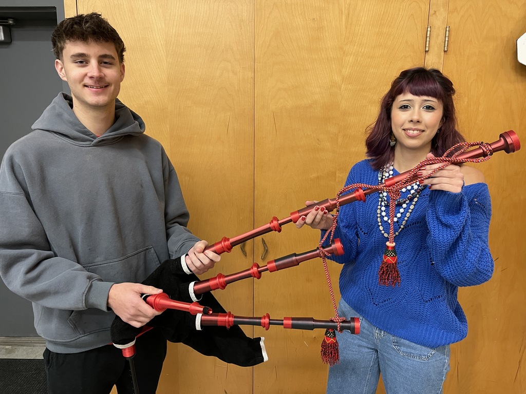 two students hold 3-D printed bagpipes