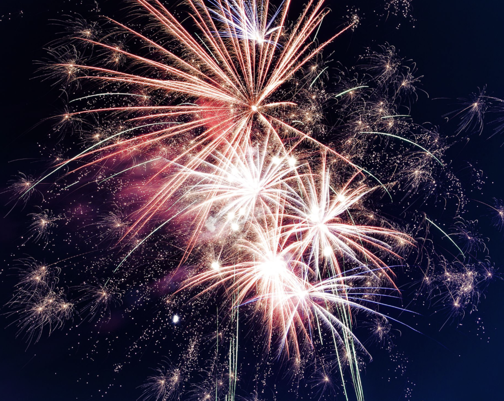 Fireworks display going off against a dark sky.