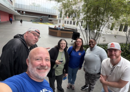 A group of PD attending staff smiles for the camera