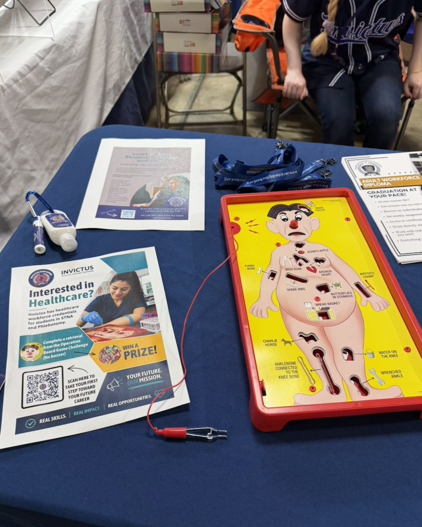 A table with info brochures on Invictus high school and an Operation board game.