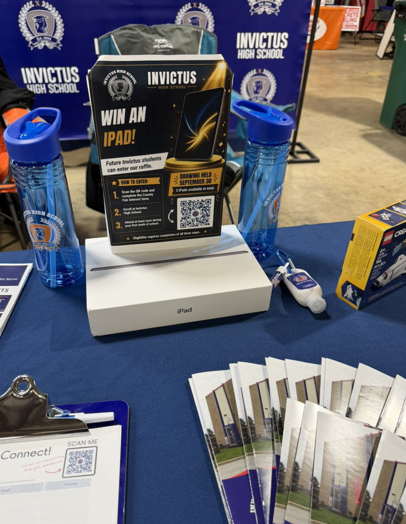 A table with info brochures on Invictus high school and information about an iPad raffle
