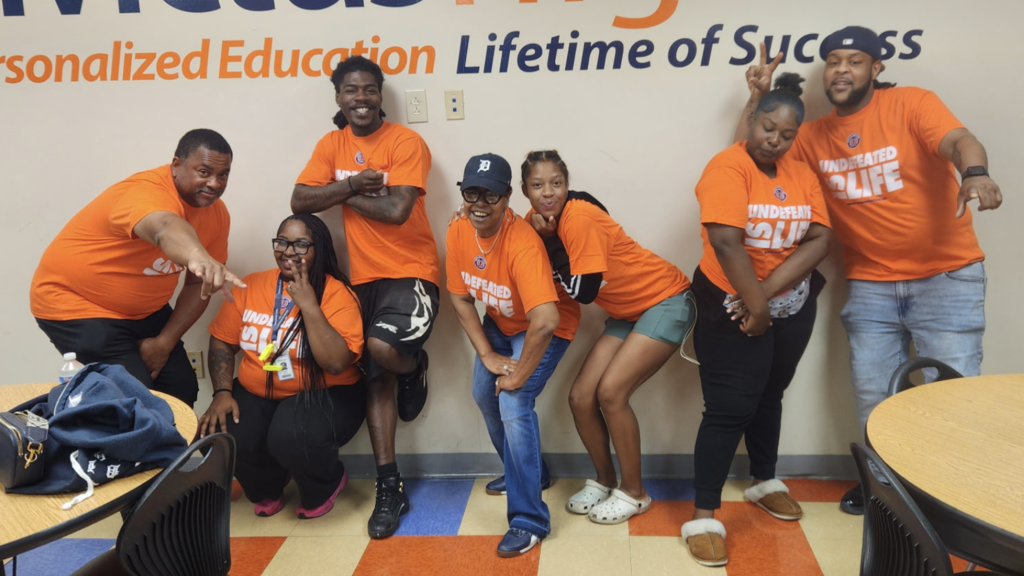 A group of Invictus staff and alumni in school swag.