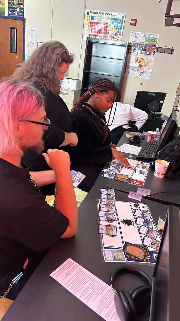 Students at the desk review Magic Cards