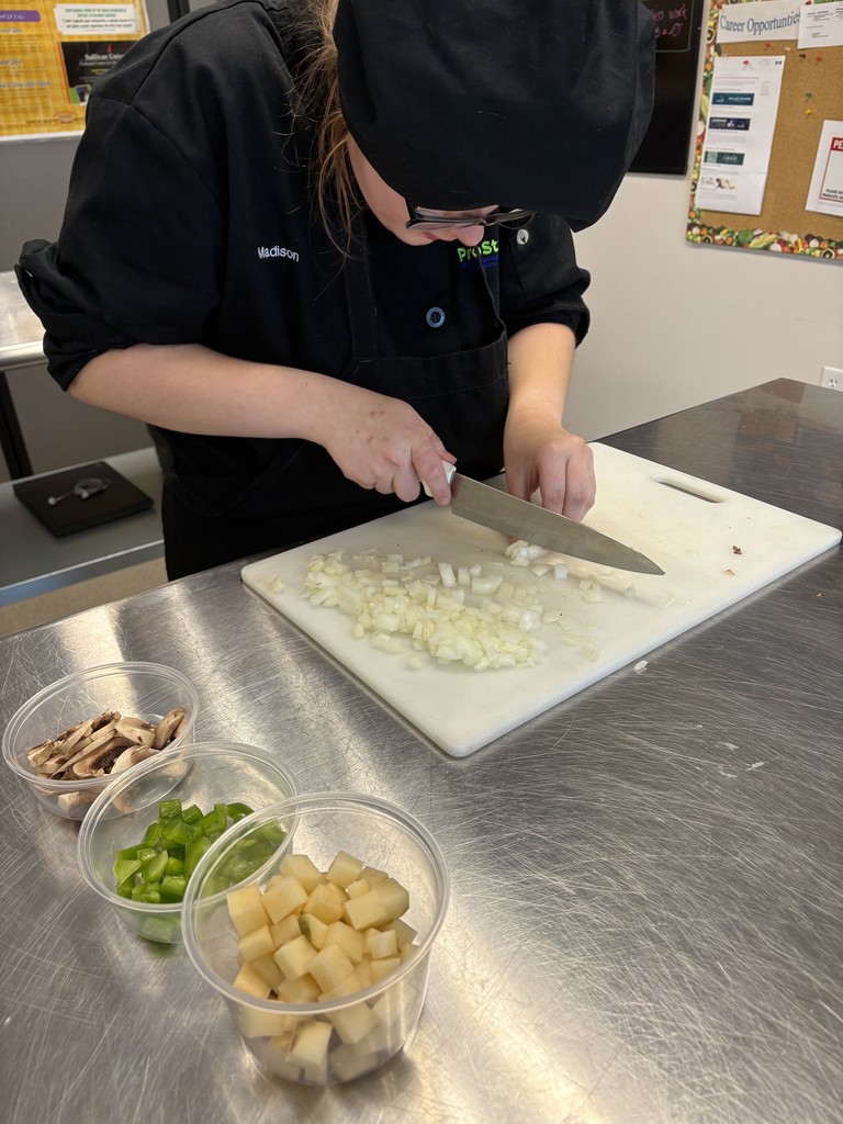 culinary student demonstrating knife cuts