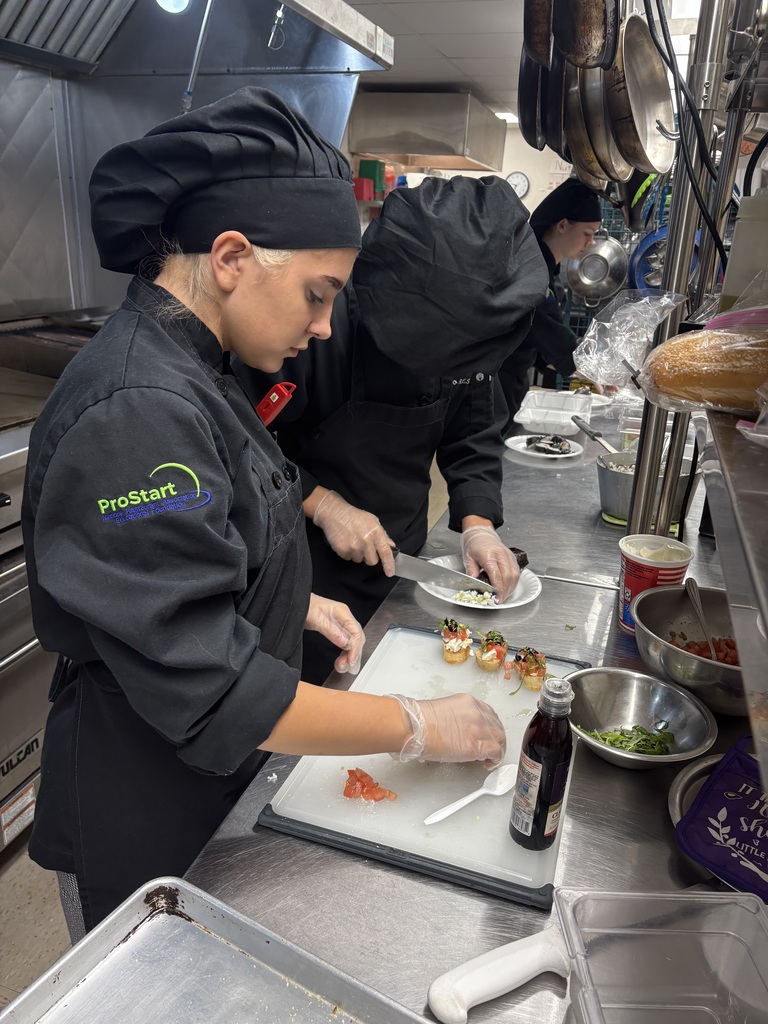 three students preparing sushi