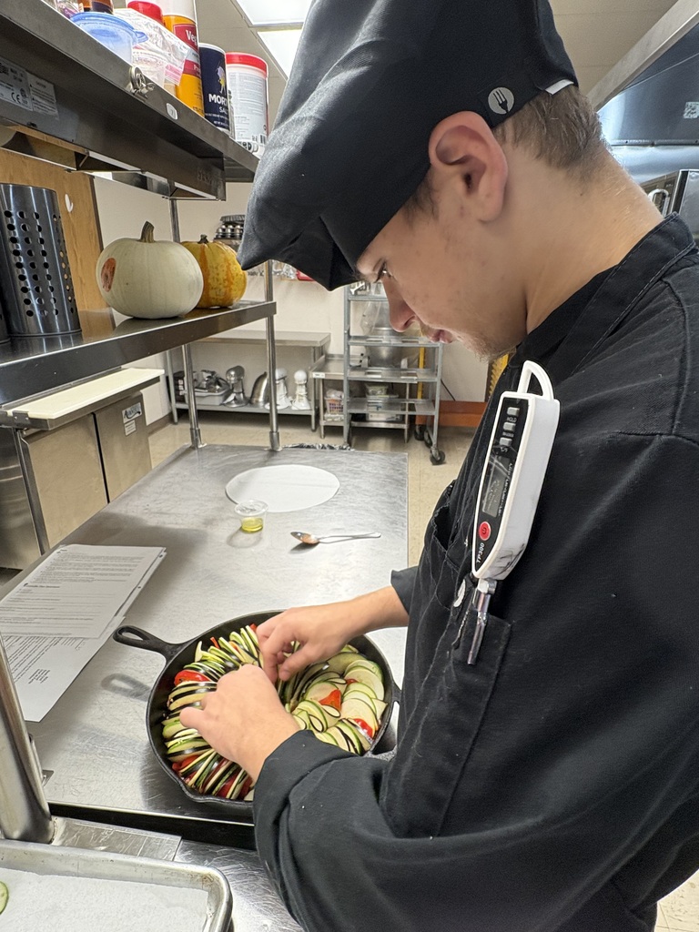 student arranging vegetables in skillet for ratatouille