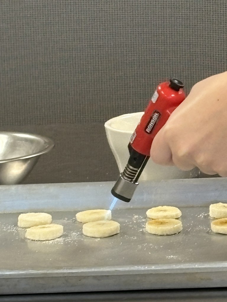 banana slices being browned with a torch
