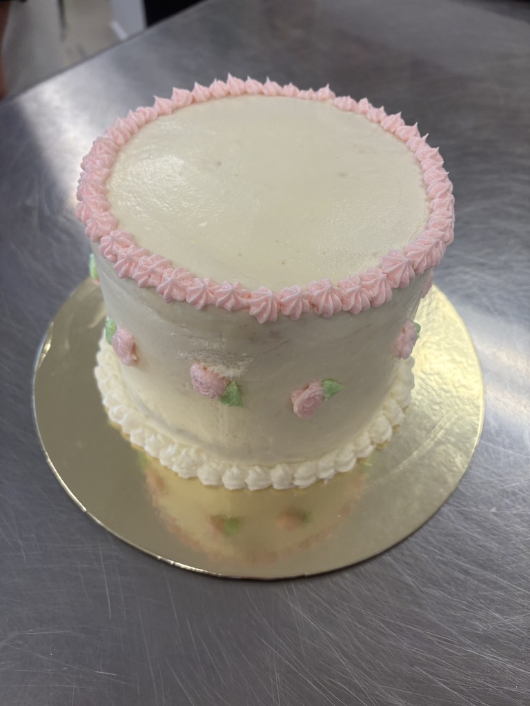 cake with white frosting and pink accents