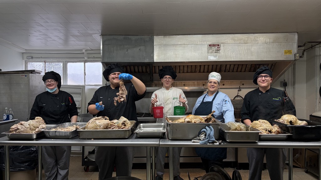 4 students preparing turkey with their teacher