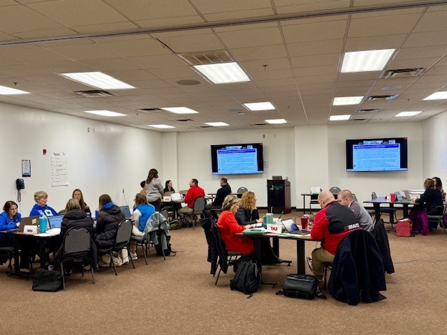 people working in groups around table