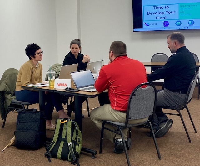 people working in a  group at a table