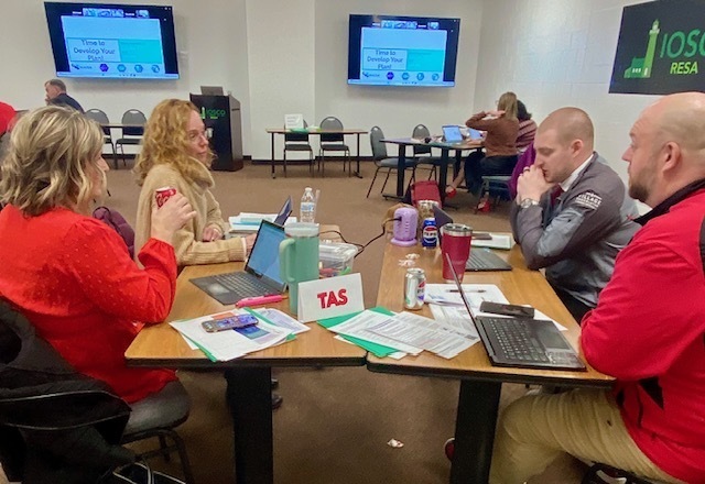 people working in groups around table